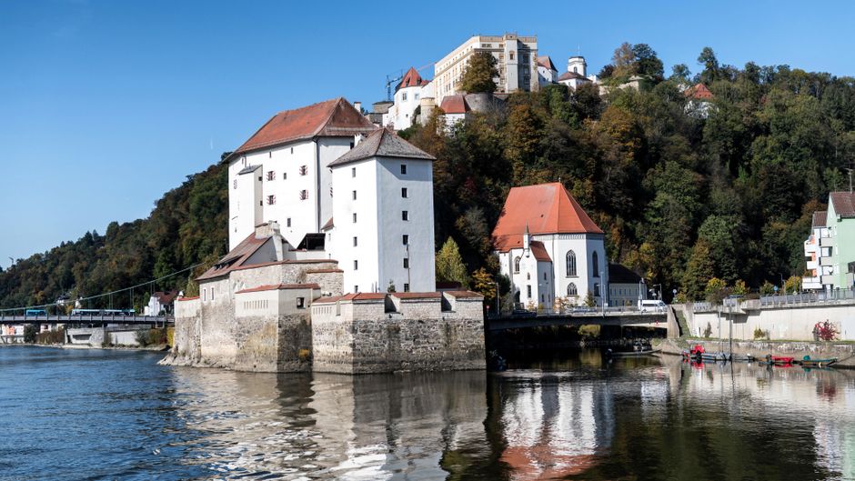 Discover the historic beauty of Passau's castles reflected in tranquil river waters.