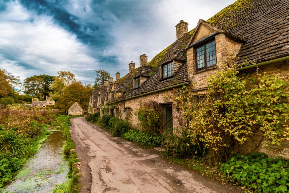 Picturesque stone cottages along a scenic road in Bibury, England, UK.