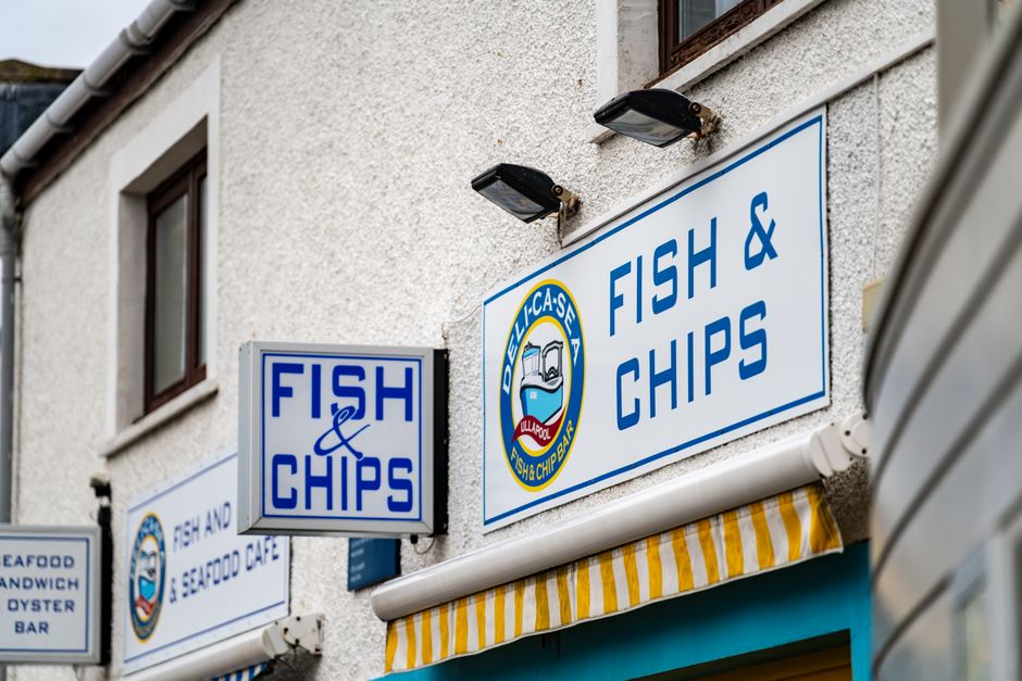 Colorful fish and chips shop facade with signage, capturing the essence of British street food culture.